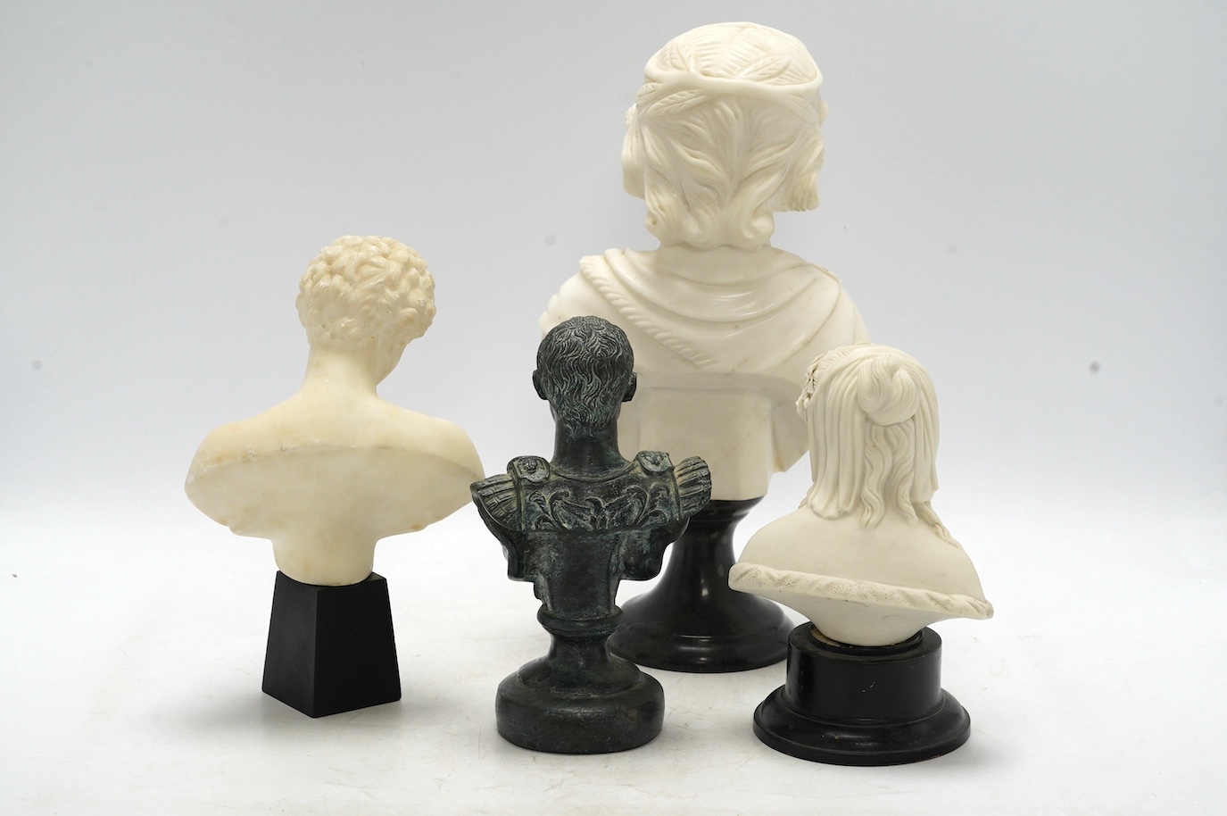 An alabaster bust of Anthony, a larger marble bust, a Parian bust on stand of a girl and a bronze bust of Julius Caesar, tallest 31cm high (4). Condition - Parian ware bust fair, other three good